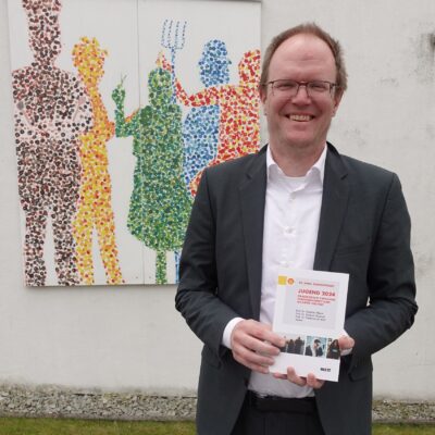 Referent der KOJA-Tagung Ingo Leven mit der Broschüre Jugend-Shell Studie 2024 in der Hand