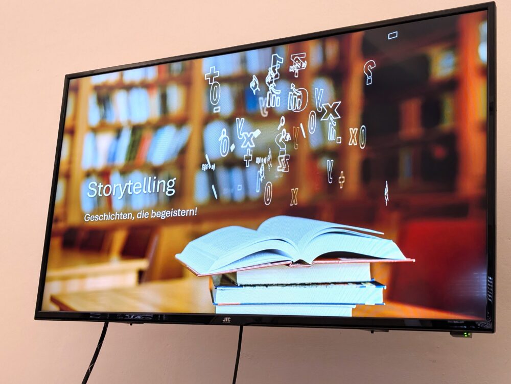 Bildschirm mit dem Schriftzug Storytelling über einem geöffneten Buch