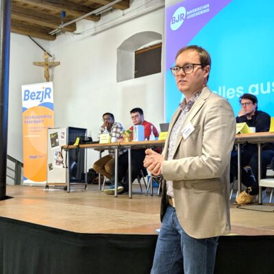 Präsident des BJR Philipp Seitz vor der Bühne während des Vortrags